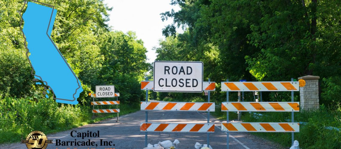 road closed sign on road with california state graphic overlaid