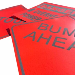 bright orange road work signs laid out on a white surface