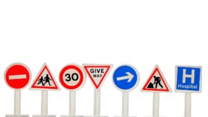 a bunch of different colored road signs lined up
