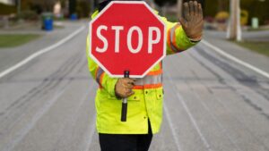 flagger holding stop sign and standing in the road