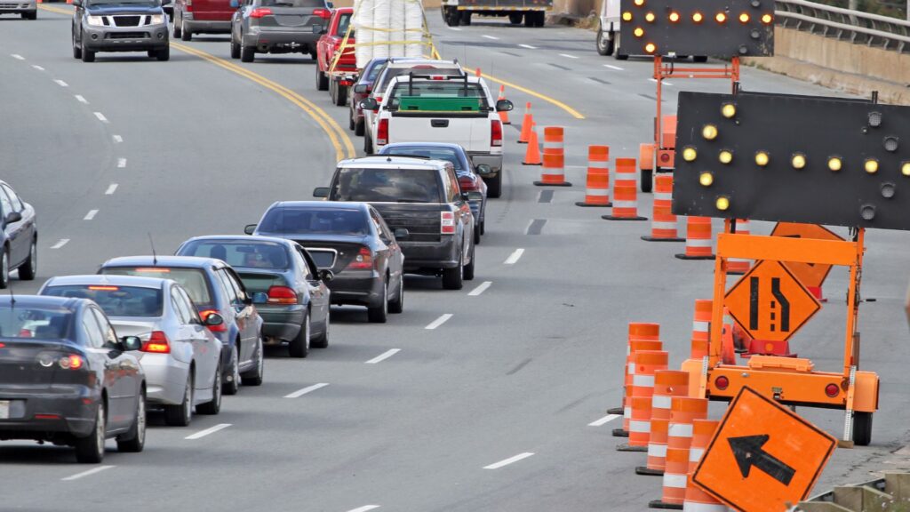 cars driving through traffic road work on the road