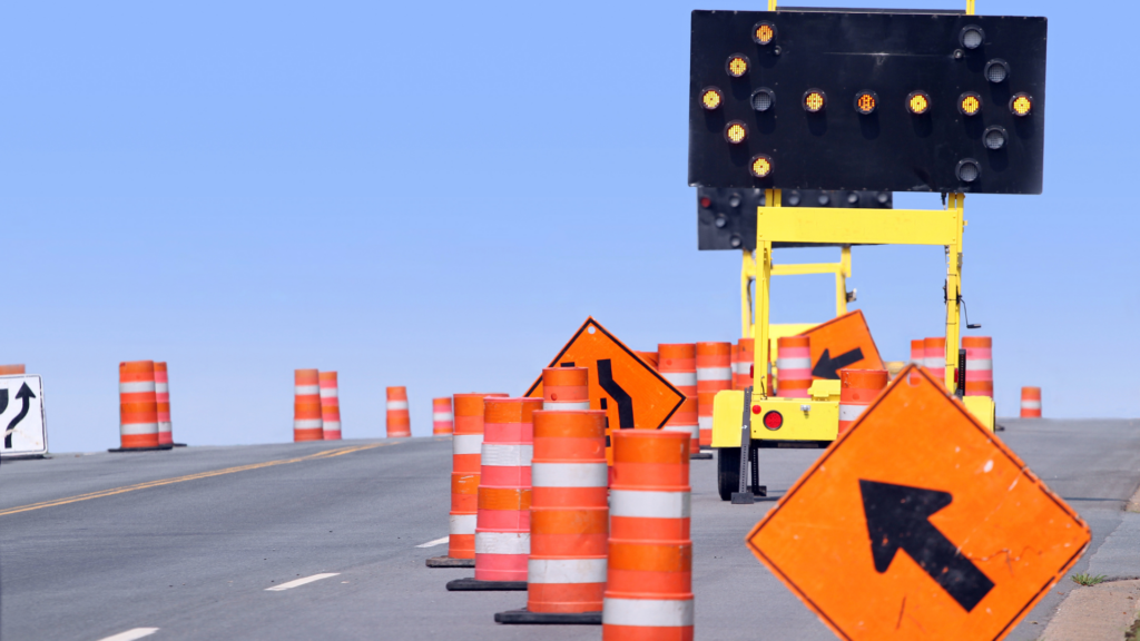 Roadwork signs all over the freeway with a lit up sign with arrow pointing.