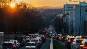 traffic on a sloped hill with the sunrise or sunset in thebackground.