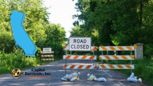 road closed sign on road with california state graphic overlaid